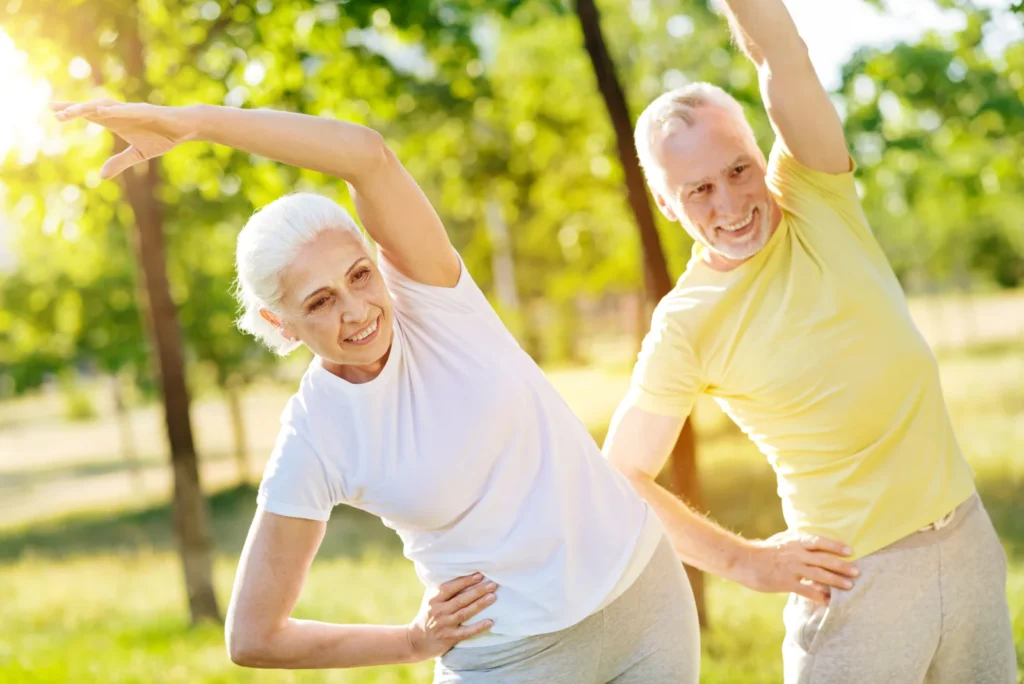 A senior couple stretching and exercising outdoors